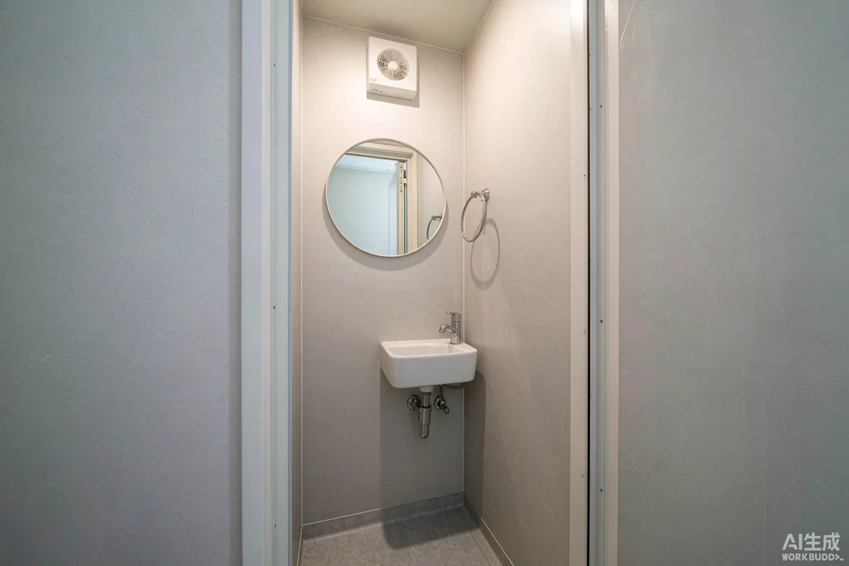 Small bathroom with wall mounted extractor fan, round mirror and towel rail