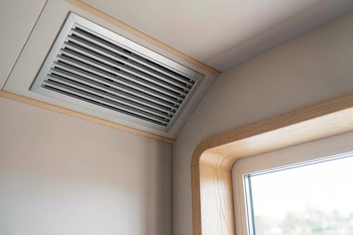 Close-up of a ventilation grille and window reveal inside a modern capsule home