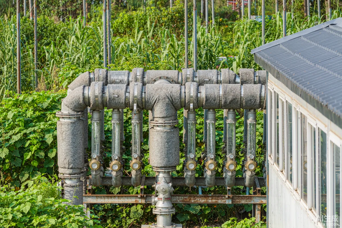 Insulated water manifold with pressure gauges feeding several prefab capsule units from a single supply line