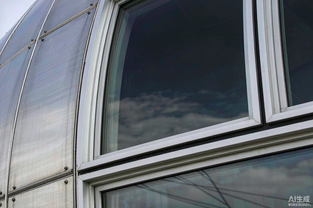 Close-up of a capsule home's curved aluminium shell meeting panoramic glazing